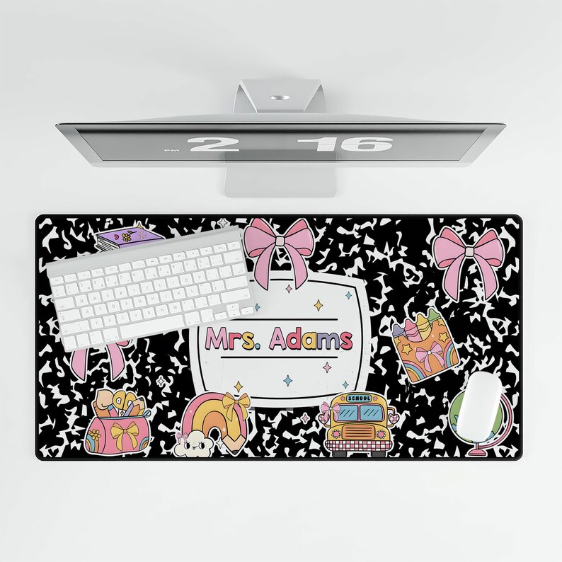 May include: Black and white desk mat with a notebook paper design. It features a school bus, rainbow, pencils, and a name tag that says "Mrs. Adams".