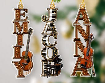 May include: Three vertical hanging ornaments featuring the names EMILY, JACOB, and ANNA. The EMILY ornament includes a guitar, the JACOB ornament features piano keys and a grand piano, and the ANNA ornament displays a violin, all with musical notes.