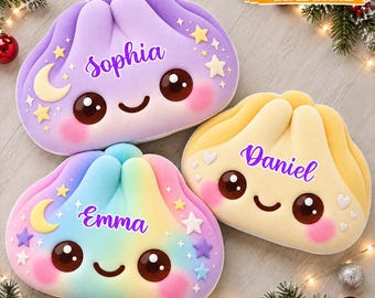 Könnte beinhalten: Drei plüschige, knödelförmige Kissen mit gestickten Gesichtern, rosigen Wangen und den personalisierten Namen Sophia, Emma und Daniel. Die Kissen sind in Pastelllila, Regenbogenfarben und Gelb gehalten und mit Sternen, Monden und Herzen verziert.