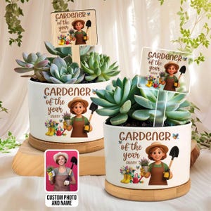 May include: Two white ceramic planters with succulents, each featuring a wooden sign that reads "GARDENER of the year SUNNY." The planters have a cartoon illustration of a gardener. One planter includes a photo with the text "CUSTOM PHOTO AND NAME."