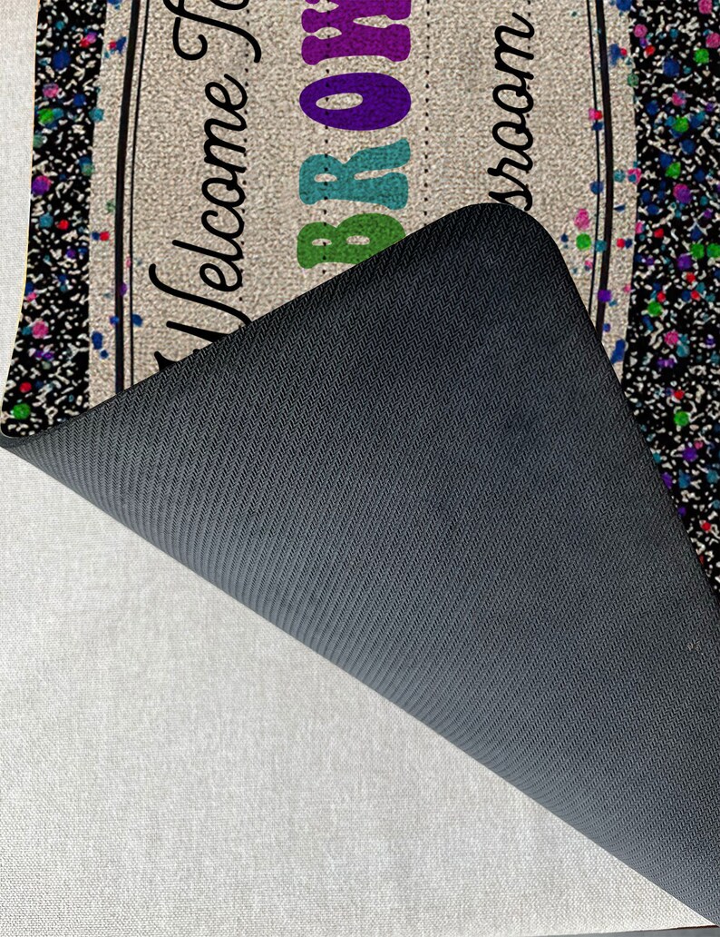 May include: Welcome to the Brown Room doormat with a black and white confetti design. The doormat has a black non-slip backing.