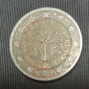 May include: A silver French 1 Euro coin with a tree and the words "Liberté, Egalité, Fraternité" around the edge. The year 1993 is printed on the bottom.
