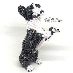 May include: A beaded dog figurine in black and white, standing on its hind legs with one paw raised. The text "Pdf Pattern" is visible on the right side. The dog is made of small, round beads.