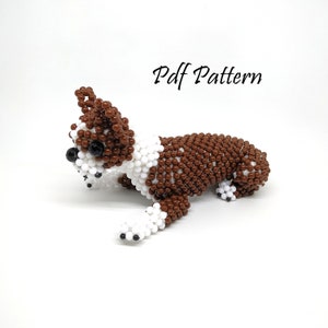 May include: A brown and white beaded dog figurine, crafted with small round beads. The dog is lying down with its head turned to the side. The figurine is a craft project and the image includes the text "Pdf Pattern".