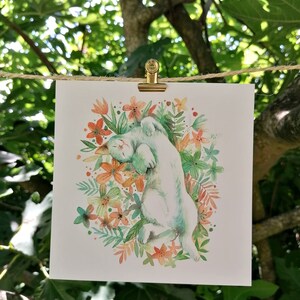 May include: A watercolor painting of a white cat curled up in a circle of green leaves and orange flowers.