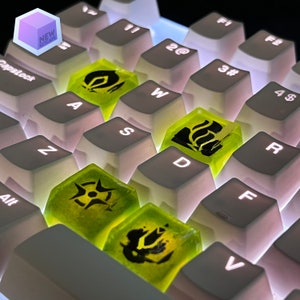 May include: A white mechanical keyboard with green keycaps featuring different symbols. The keycaps are translucent and glow in the dark.