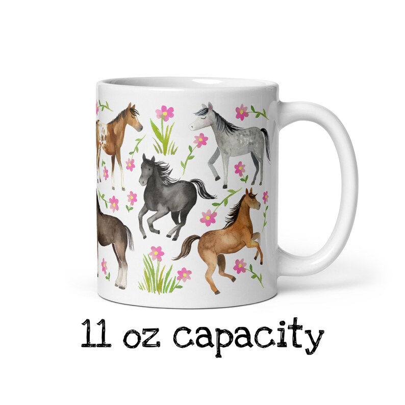 May include: White ceramic mug with a colorful design of horses and pink flowers. The mug has a 11 oz capacity.