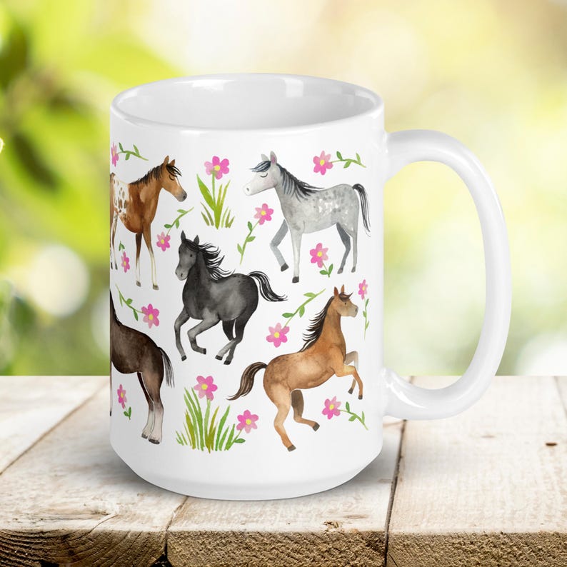 May include: White ceramic mug with a colorful pattern of horses and pink flowers. The horses are in various poses and colors, including brown, gray, and black.