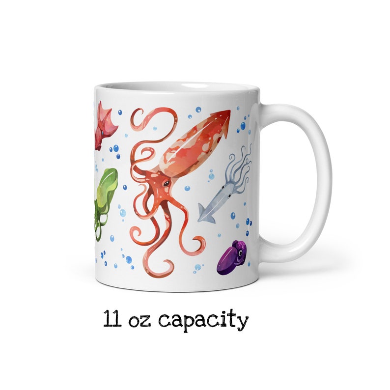 May include: White ceramic mug featuring watercolor illustrations of various squid species in shades of red, orange, green, and purple, with blue bubbles. The mug has an 11 oz capacity.