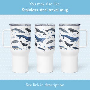 May include: White stainless steel travel mug with a blue watercolor whale design. The mug has a lid and a handle.