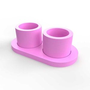 May include: A pink ceramic planter with two separate pots, each with a round opening. The planter is designed to hold two small plants or succulents.