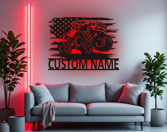May include: A black metal wall art piece featuring a red monster truck design set against a distressed American flag. The text "CUSTOM NAME" is displayed below the truck. The artwork is mounted above a grey sofa in a modern living room.