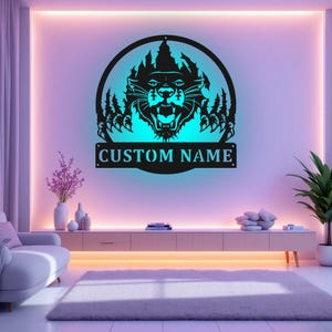 May include: Black metal wall art featuring a panther with glowing eyes and a custom nameplate. The art is mounted on a wall with a light blue background.