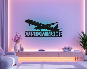 Puede incluir: Silueta negra de metal de un avión despegando con el texto "CUSTOM NAME" debajo. La silueta está montada en una pared en un salón.
