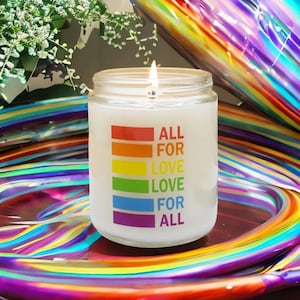 May include: A white candle with a rainbow design and the text "ALL FOR LOVE LOVE FOR ALL". The candle is lit and sitting on a rainbow-colored surface.