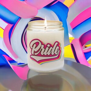 May include: A lit white candle in a glass jar with the word "Pride" in a pink and blue design. The background features abstract ribbons in pink, blue, and white.