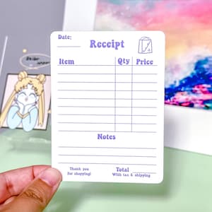 Op de afbeelding: Een blanco ontvangstbon-sjabloon met een paarse rand en een cartoon-winkelzakje met een hartje in de hoek. De ontvangstbon heeft secties voor datum, artikel, hoeveelheid, prijs, notities en totaal inclusief btw en verzendkosten.