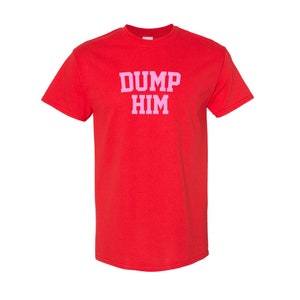 May include: Red t-shirt with the text "DUMP HIM" in pink letters.