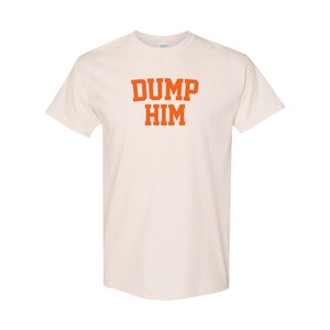 May include: A white t-shirt with the text "DUMP HIM" printed in orange.