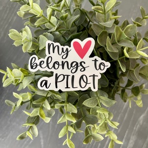 May include: White sticker with black text that reads "My heart belongs to a PILOT" with a red heart in the middle.