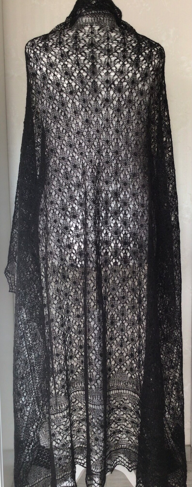 Puede incluir: Chale de encaje negro con un patr&oacute;n delicado. El chal est&aacute; hecho de una tela ligera y transpirable, perfecto para agregar un toque de elegancia a cualquier atuendo.