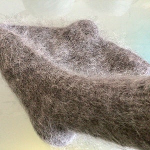 May include: A soft, grey, fuzzy scarf made of mohair or angora.