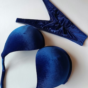 Puede incluir: Un top de bikini de terciopelo azul con tirantes ajustables. El top presenta un escote pronunciado y un estilo push-up.