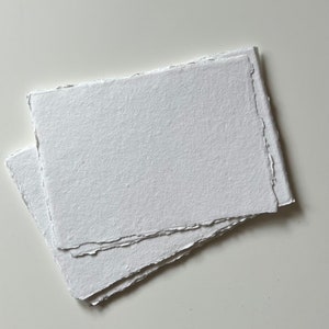 Peut inclure: Deux feuilles de papier blanc textur&eacute; avec des bords festonn&eacute;s.