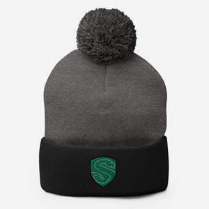 May include: A gray and black knit beanie with a pom pom on top. The beanie has a green snake logo on the front.