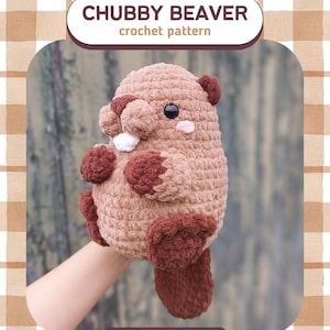 May include: A crocheted beaver plushie in shades of brown, with dark brown accents on its paws, ears, and tail. The beaver has a white tooth and pink cheeks. The text "CHUBBY BEAVER crochet pattern" is displayed above the beaver.