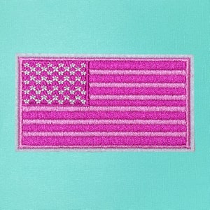 May include: A pink and white embroidered American flag patch with a white border.