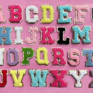 May include: A set of colorful felt letters in a variety of colors, including pink, blue, yellow, green, and purple. The letters are arranged in alphabetical order and are perfect for crafting projects.