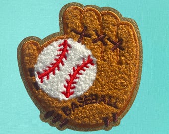 May include: A brown felt baseball glove with gold glitter trim and a white baseball with red stitching. The glove has the word "Baseball" embroidered on it.