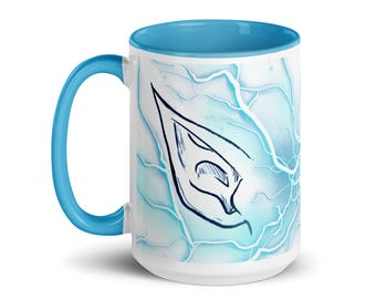 May include: A white ceramic mug with a blue rim and handle. The mug features a blue and white abstract design with a black outline of an elf ear.