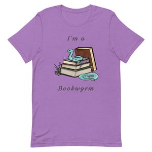 May include: Purple t-shirt with a light blue snake curled around a stack of books. The text "I'm a Bookwyrm" is printed on the shirt.