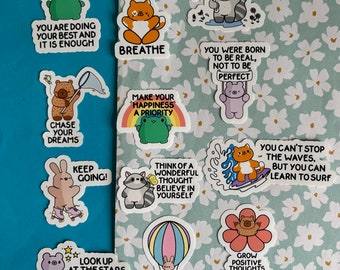 May include: A collection of colorful stickers with positive affirmations and cute illustrations. The stickers feature phrases like "You are doing your best and it is enough", "Just breathe", "Make your happiness a priority", "Think of a wonderful thought, believe in yourself", "Chase your dreams", "Keep going!" and "Look up at the stars, not down at your feet".