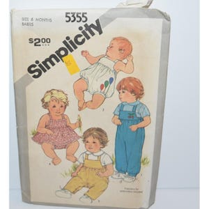 May include: A Simplicity sewing pattern envelope, number 5355, for babies size 6 months. The front features illustrations of four children wearing various outfits including a romper with balloons, a floral dress, yellow overalls, and blue overalls.