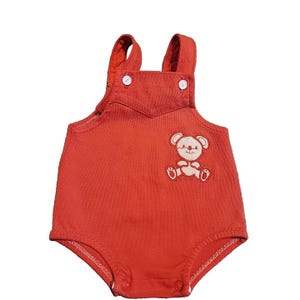 May include: A red baby romper with white buttons and straps. The romper features a white embroidered teddy bear design on the front. The garment is made of a soft fabric and has a button closure at the bottom.