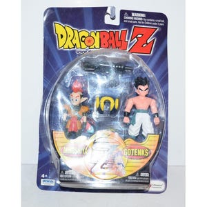 May include: Dragon Ball Z action figure set in a sealed package. The package features two figures, a yellow ring, and two black accessories. The figures are labeled "MINOSHIYA" and "GOTENKS". The packaging includes the Dragon Ball Z logo and the text "WARNING: CHOKING HAZARD".