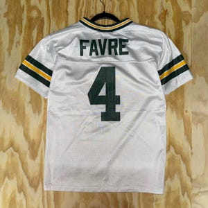 Op de afbeelding: Wit mesh jersey met groene en gouden accenten. De jersey heeft de naam "FAVRE" in groene blokletters boven het nummer "4" in groen. De mouwen hebben groene en gouden strepen. De kraag heeft groene en gouden afwerking.