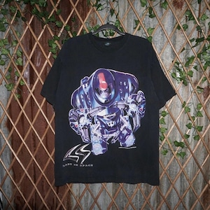 Op de afbeelding: Zwart T-shirt met een grote afbeelding van een futuristische robot in blauw, paars en rood. De tekst "LOST IN SPACE" is in het wit onder het robotontwerp gedrukt. Het shirt hangt aan een zwarte hanger.