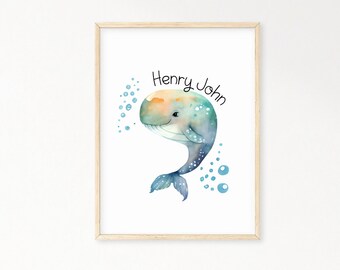 May include: A watercolor print of a blue whale with a light orange belly, swimming with blue bubbles. The print has the name "Henry John" written in black cursive.