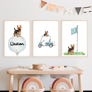Puede incluir: Tres impresiones en acuarela enmarcadas con un Yorkshire Terrier. Una impresión muestra al perro sobre una pelota de golf con el nombre "Weston". Otra muestra al perro en un carrito de golf, y la tercera muestra al perro cerca de una bandera de golf.