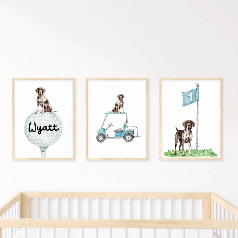 Op de afbeelding: Drie ingelijste prints met een bruine en witte hond. De eerste print toont de hond die op een golfbal staat met de naam Wyatt erop. De tweede print toont de hond die in een blauwe golfkar rijdt. De derde print toont de hond die naast een golfvlag staat.