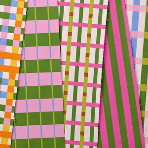 May include: A collection of colorful fabric swatches with various geometric patterns. Designs include plaid, stripes, and grid patterns in shades of green, pink, blue, yellow, and orange. The fabrics are arranged side by side, showcasing the different designs.