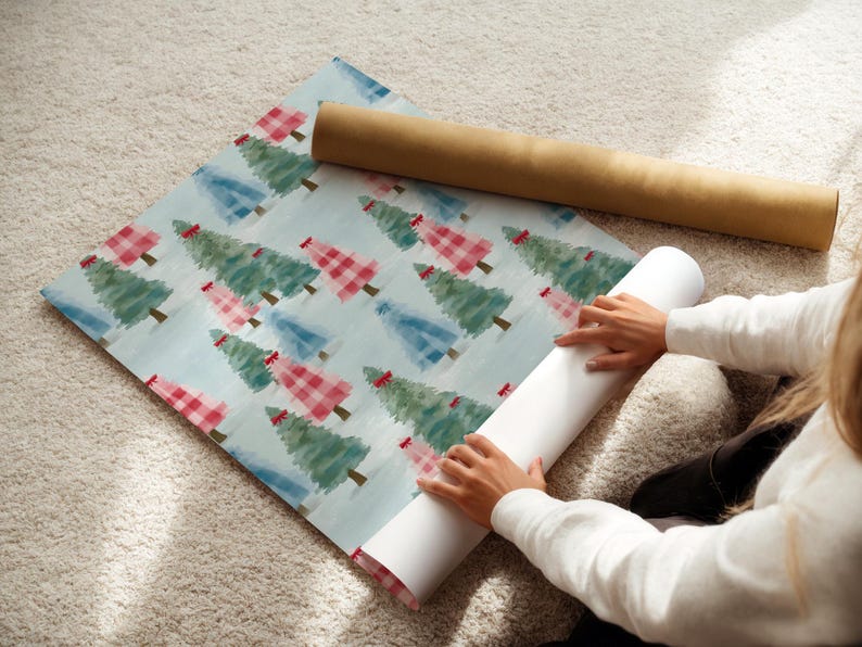 May include: Wrapping paper featuring a repeating pattern of Christmas trees in red, green, and blue on a light blue background. A brown cardboard tube and a white paper roll are also visible.