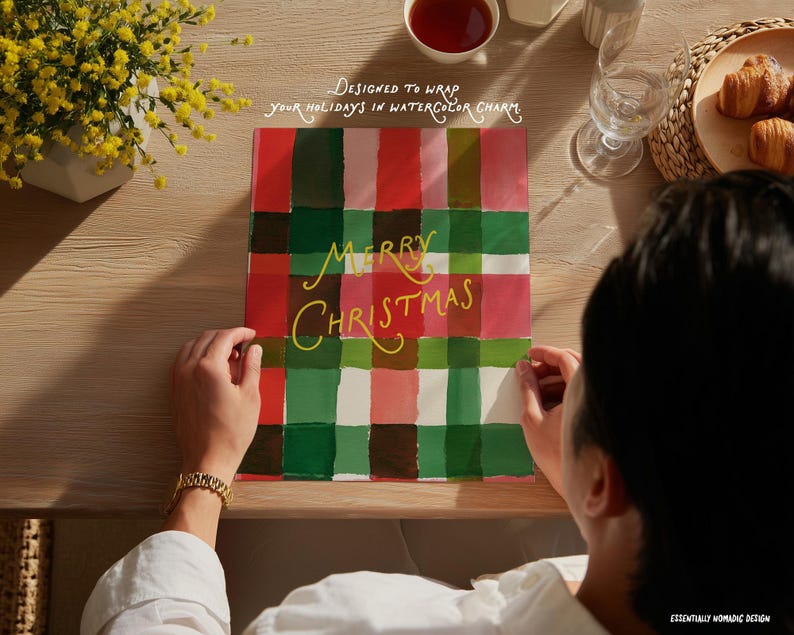 May include: A Christmas gift wrap with a plaid design in red, green, and pink. The words "MERRY CHRISTMAS" are written in yellow script. The image also includes text that says "DESIGNED TO WRAP your holidays in watercolor charm."