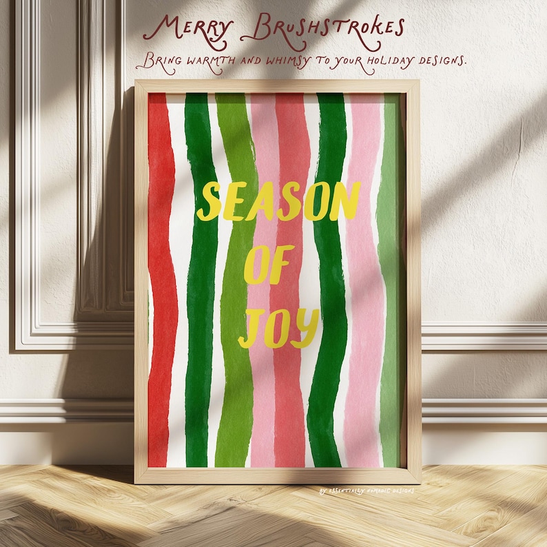 May include: A framed art print with a colourful, abstract design. Vertical stripes in red, green, and pink create a vibrant background. The words "SEASON OF JOY" are in yellow, with the text "MERRY BRUSHSTROKES" above. The frame is light wood.