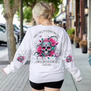 May include: White sweatshirt with a pink and green sugar skull graphic and the text "Don't try to figure me out I'm a special kind of twisted".
