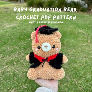 Puede incluir: Un oso marrón tejido a ganchillo con birrete y toga negros con un acento rojo. El oso tiene un hocico blanco, mejillas rosadas y sostiene una borla roja. El texto en la parte superior dice "BABY GRADUATION BEAR CROCHET PDF PATTERN".